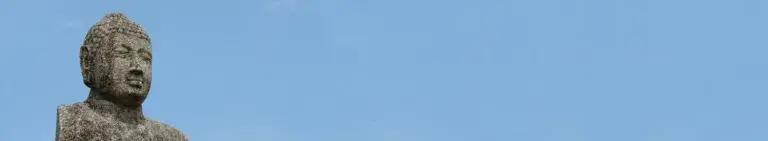 Decorative banner showing a the head and shoulders of a Buddhist statue against a blue sky.