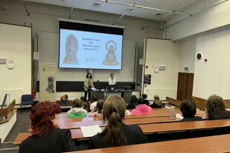 A lecture theatre with pupils watching a talk about Buddhist art